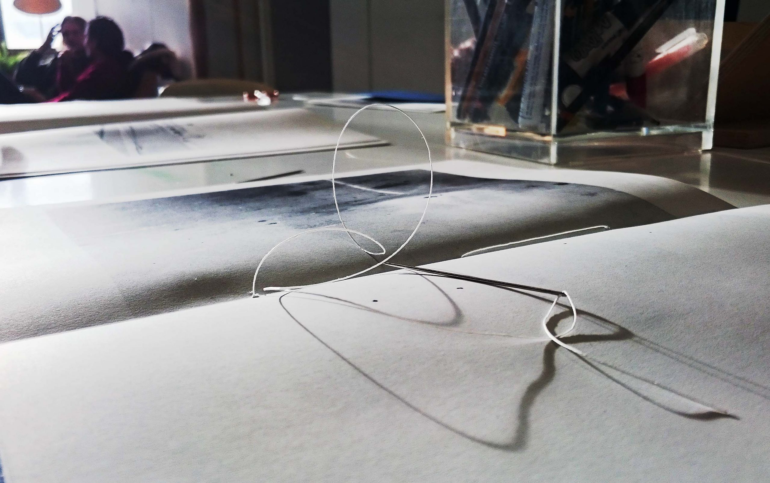A needle and yarn on open zine.