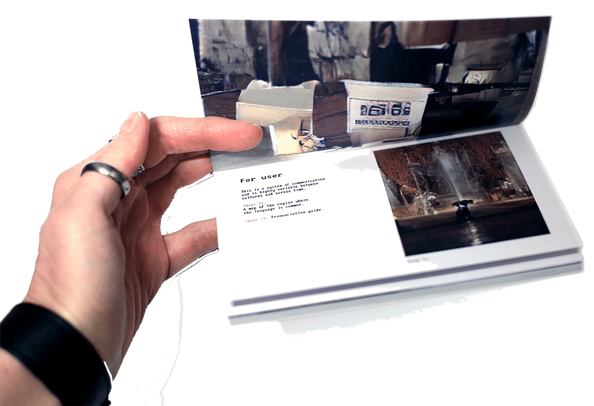 Hand holding the open book, on the page written 'for user' with two abstract images.